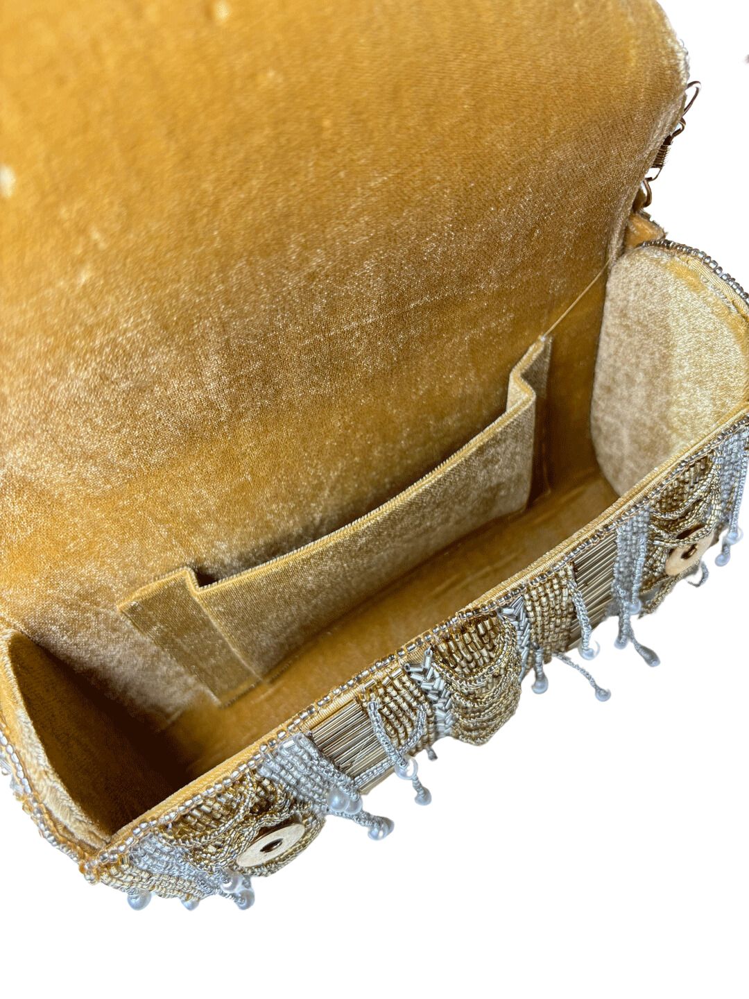 Gold beaded clutch bag with pearl accents on a neutral background