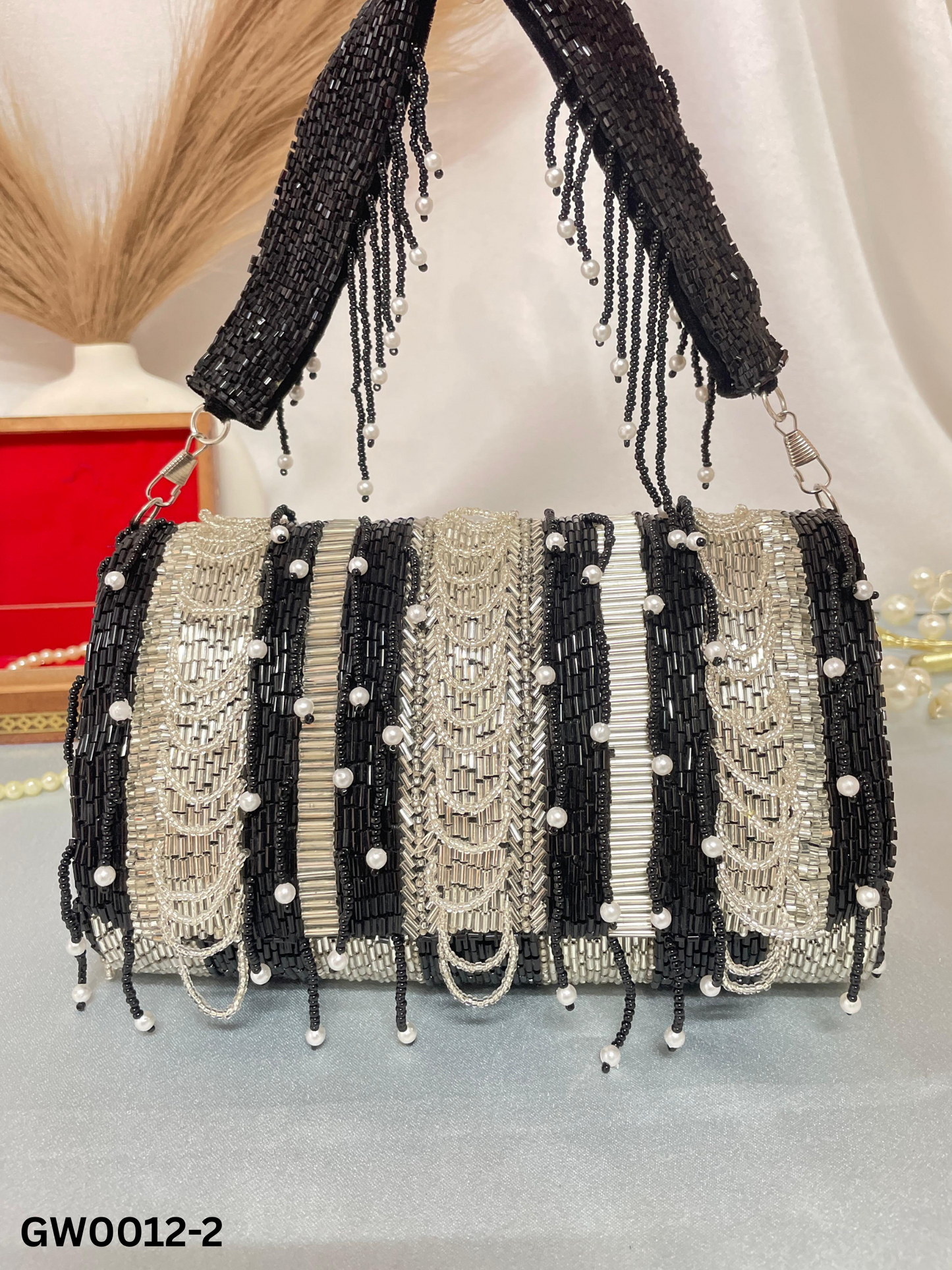 black beaded clutch bag with pearl accents on a neutral background