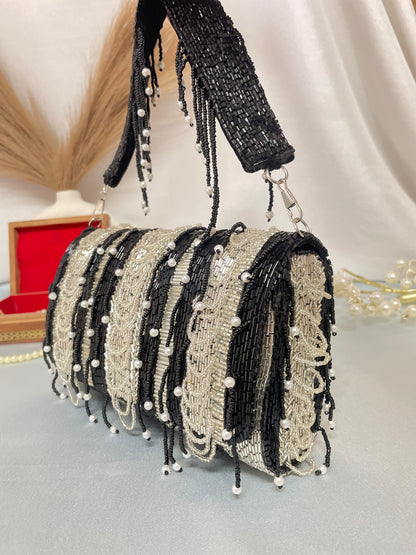 black beaded clutch bag with pearl accents on a neutral background